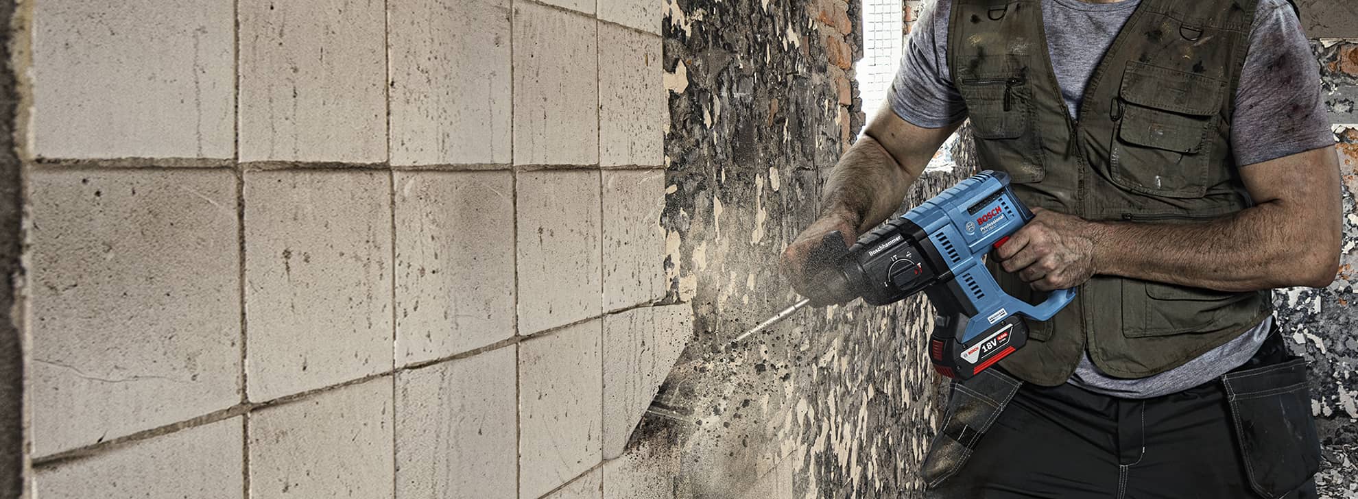 一名工匠在牆上使用藍色博世專業鑽頭。