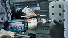 一把藍色博世專業電動螺絲刀被握在一塊金屬上。